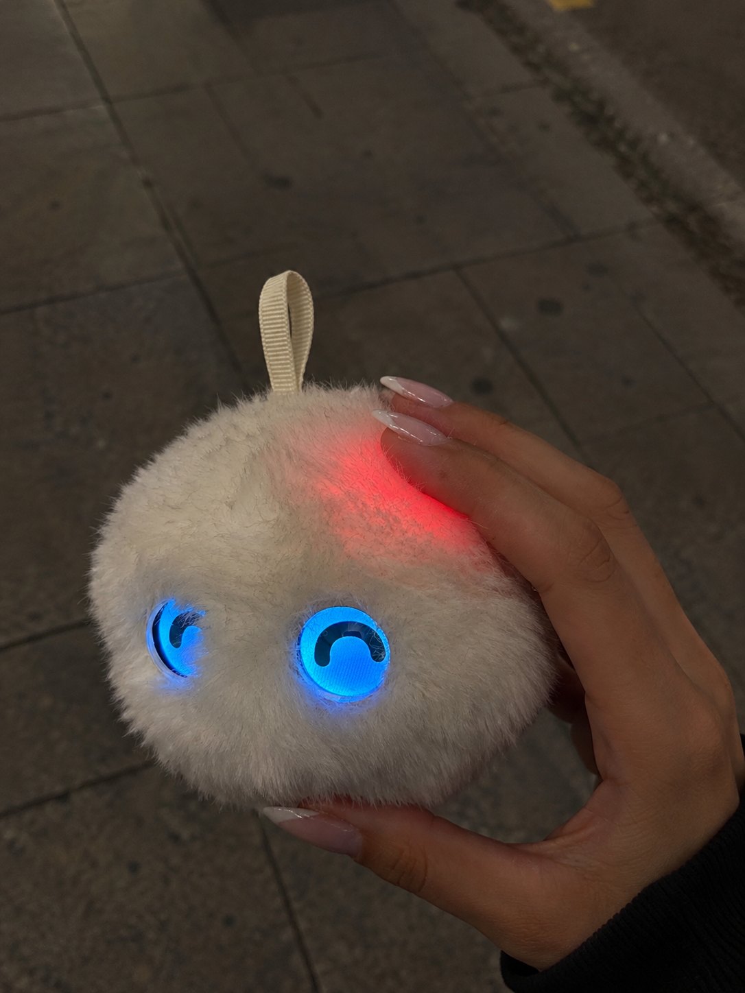 mano apretando la cabeza de un mimu que se ilumina en rojo